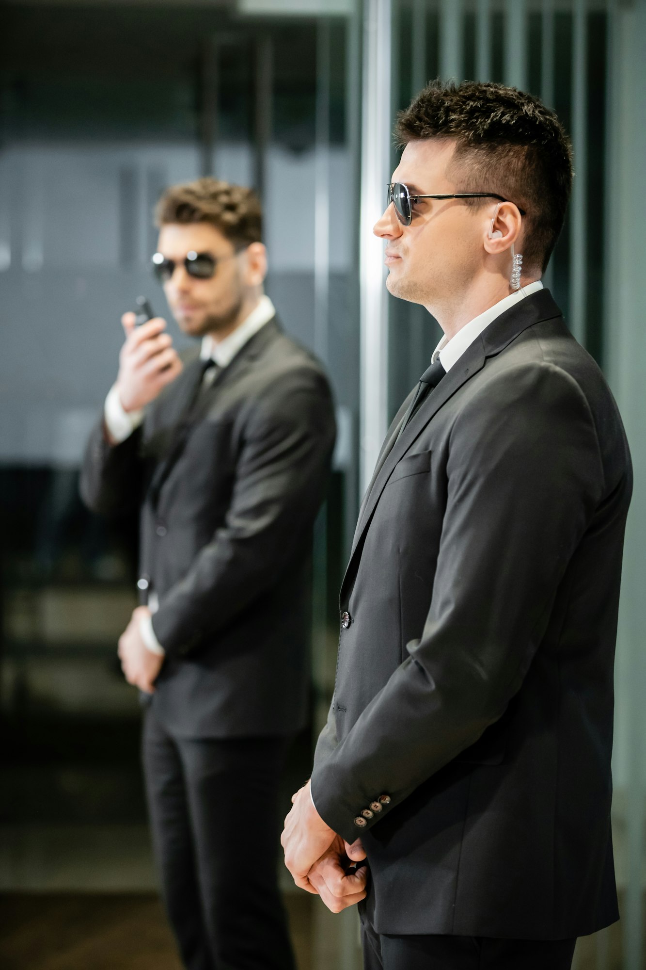 bodyguard service, private security, professionals in suit and sunglasses standing in hotel lobby